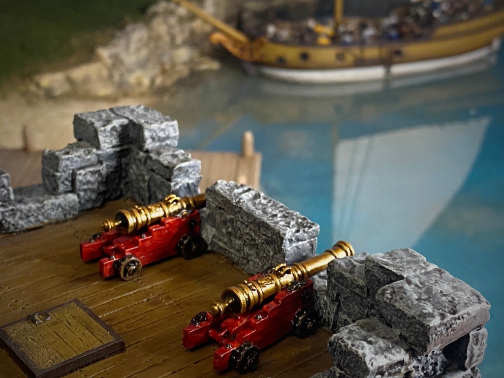 2 Bronze cannons on a stone fort overlooking a harbor