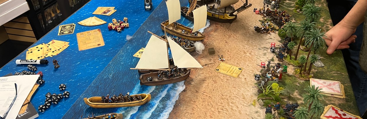 pirate ships and longboats assaulting a beach in an amphibious game of Blood & Plunder