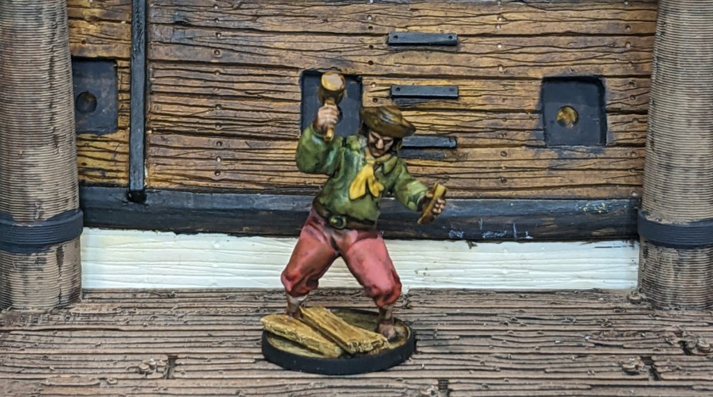 28mm Carpenter model on a dock next to a ship