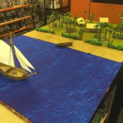 Caribbean jungle shoreline with scatter terrain, 3 buildings and a sloop