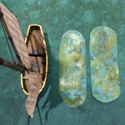 Shoal terrain templates next to a resin sloop model